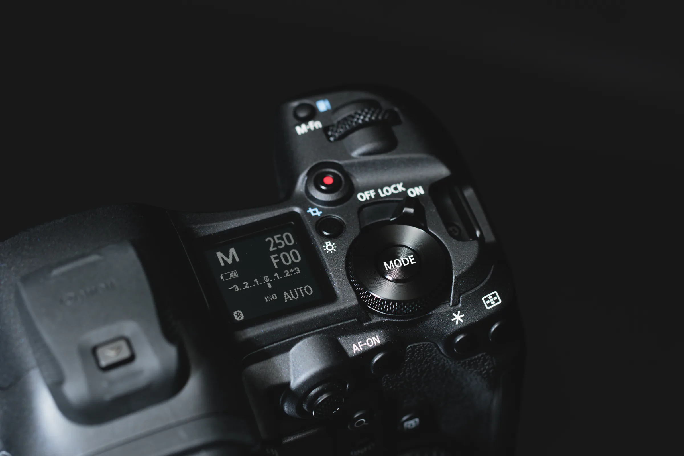 暗い背景の中でCanonカメラの上面操作部を捉えた写真